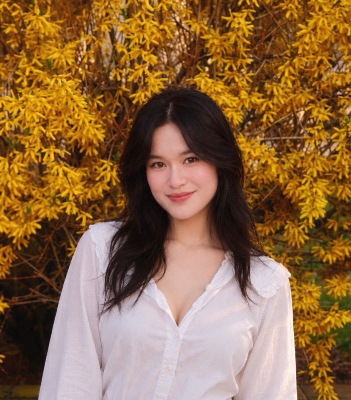 Madison smiling in front of blooming forsythia